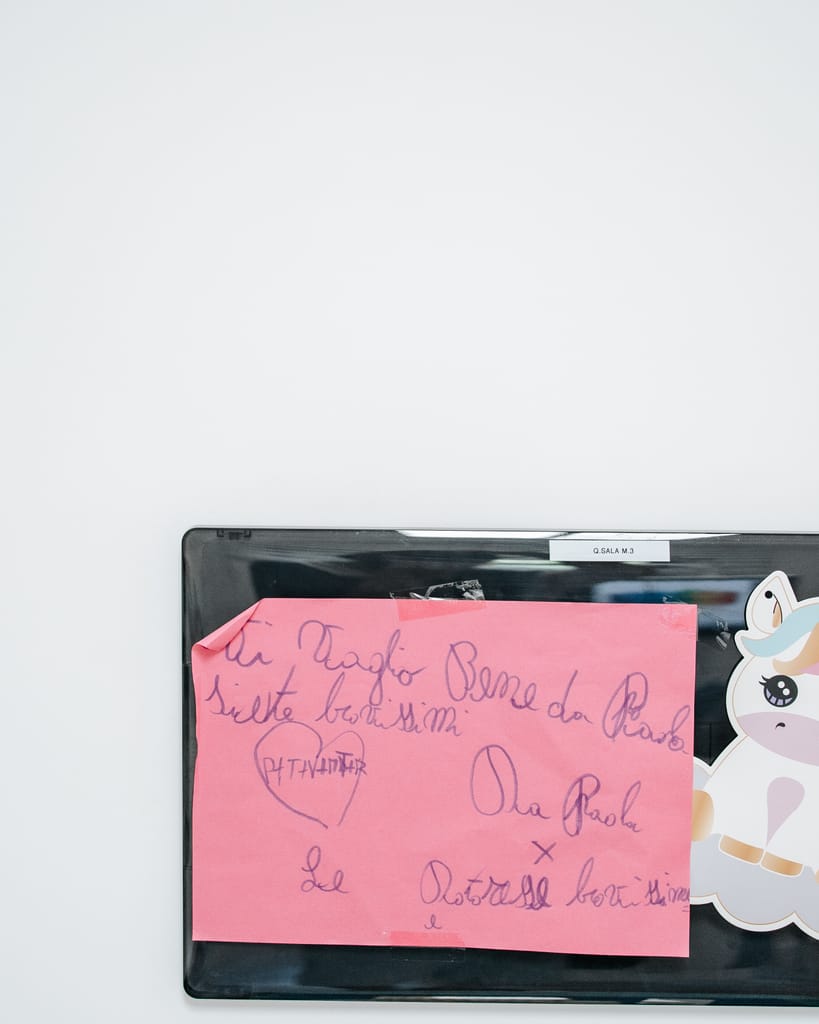 Bigliettino rosa scritto a mano da una paziente, attaccato allo schermo della sala, TCL Dental